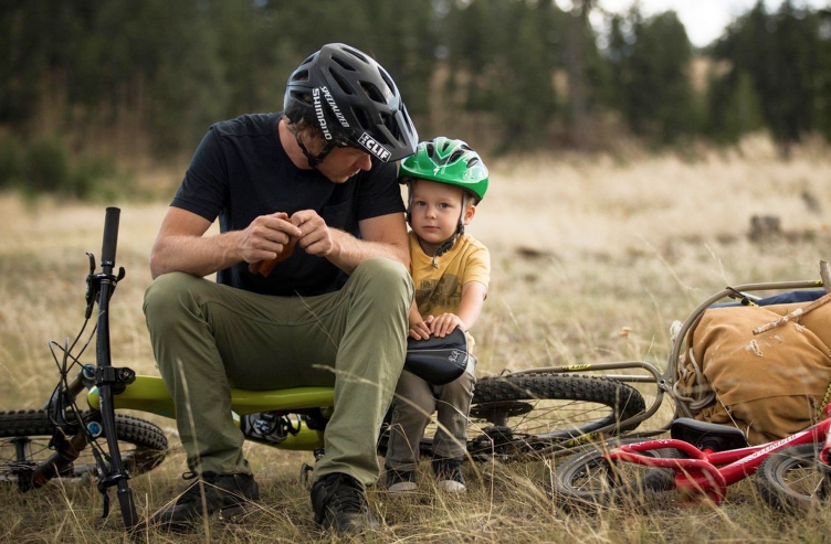 Man with a boy resting under a bike
