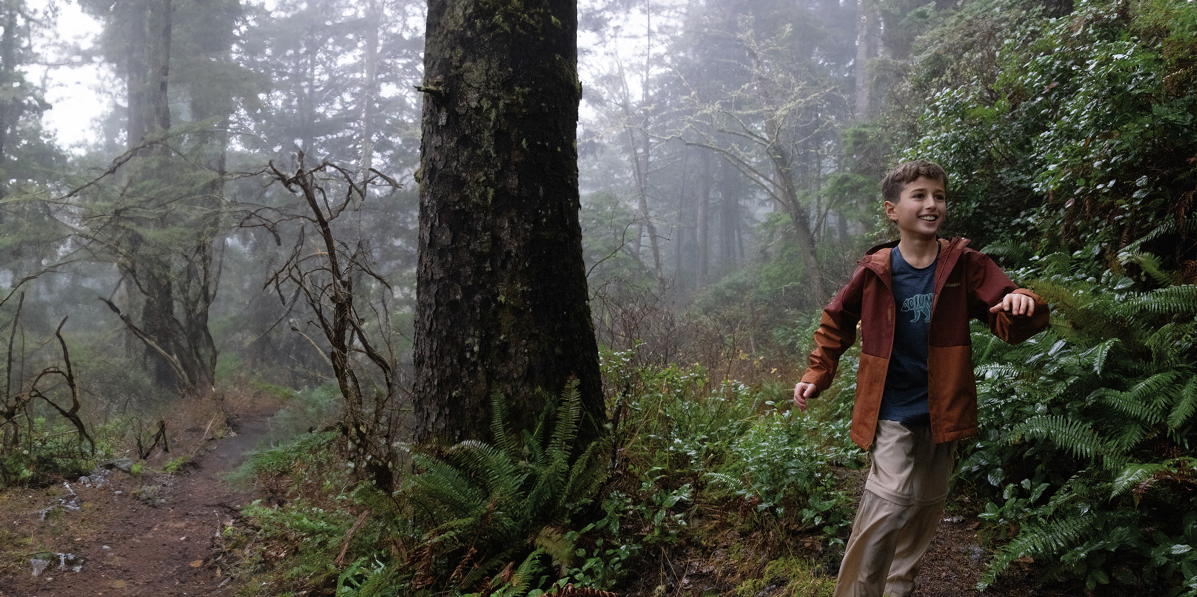 A boy running in the woods