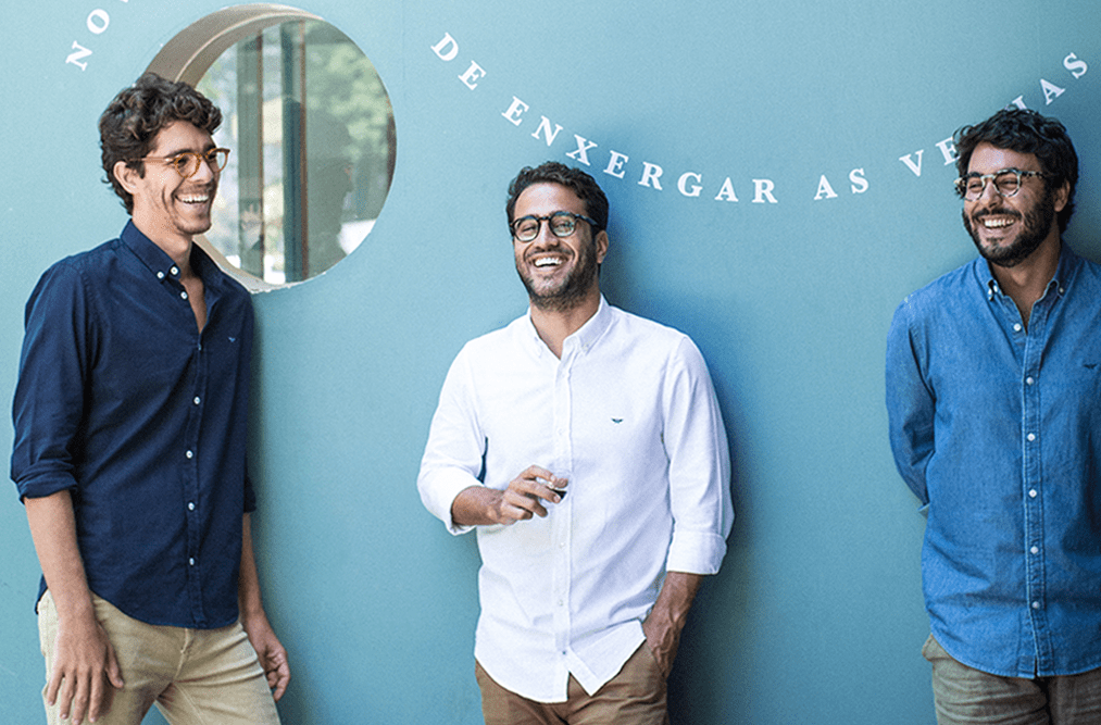 uma imagem com Hugo, Luiz e Rodrigo, conversando e sorrindo e vestidos com roupas da marca aviator